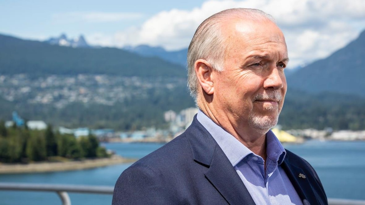 John Horgan pose devant un plan d'eau.