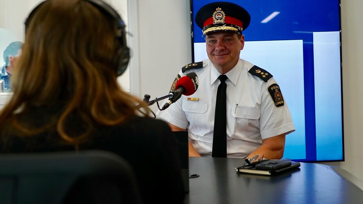Un homme en uniforme de police parle dans un micro