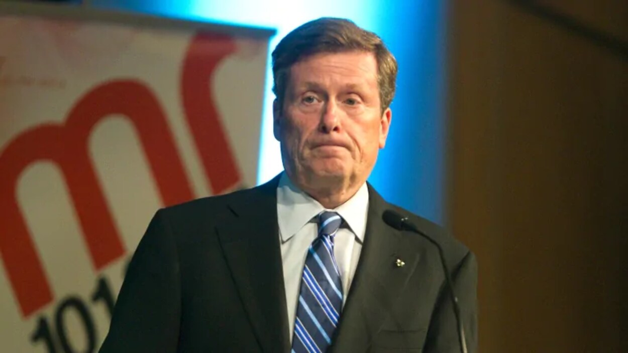 Le maire John Tory devant un micro.
