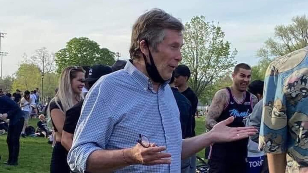 John Tory a abaissé son masque alors qu'il parle à quelqu'un.
