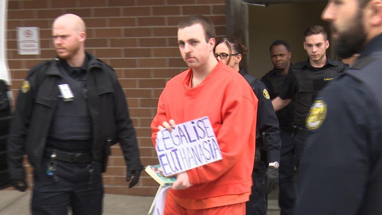 L'homme en habit de prison entouré de plusieurs shérifs.