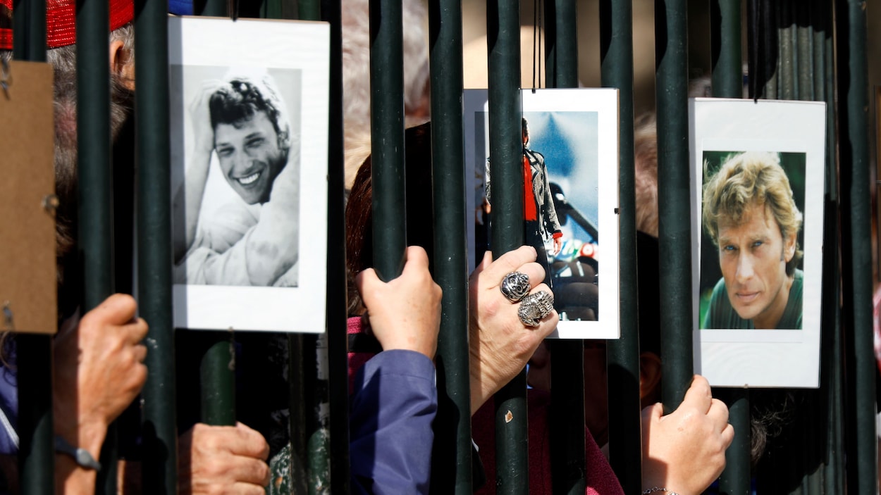Des admirateurs de Johnny Hallyday ont affiché des photos de leur idole sur la grille de l'église.