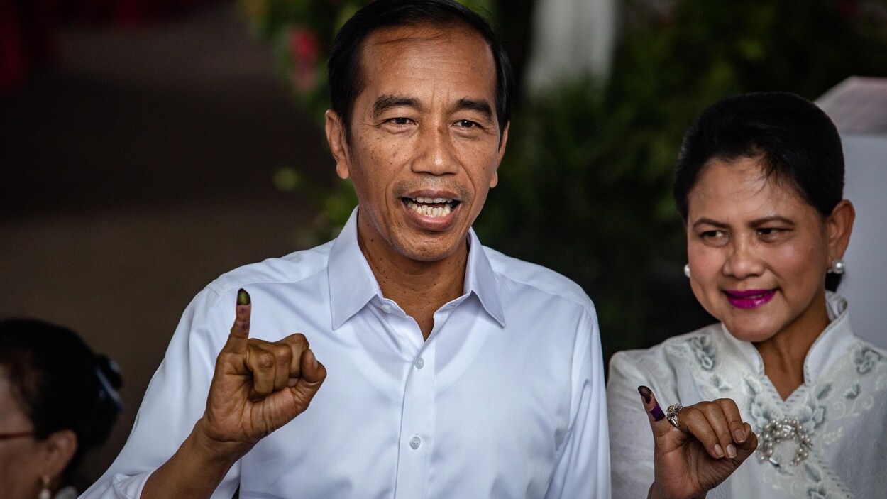Le président sortant de l'Indonésie, Joko Widodo et sa femme exhibent leur doigt trempé dans l'encre après avoir exercé leur droit de vote.