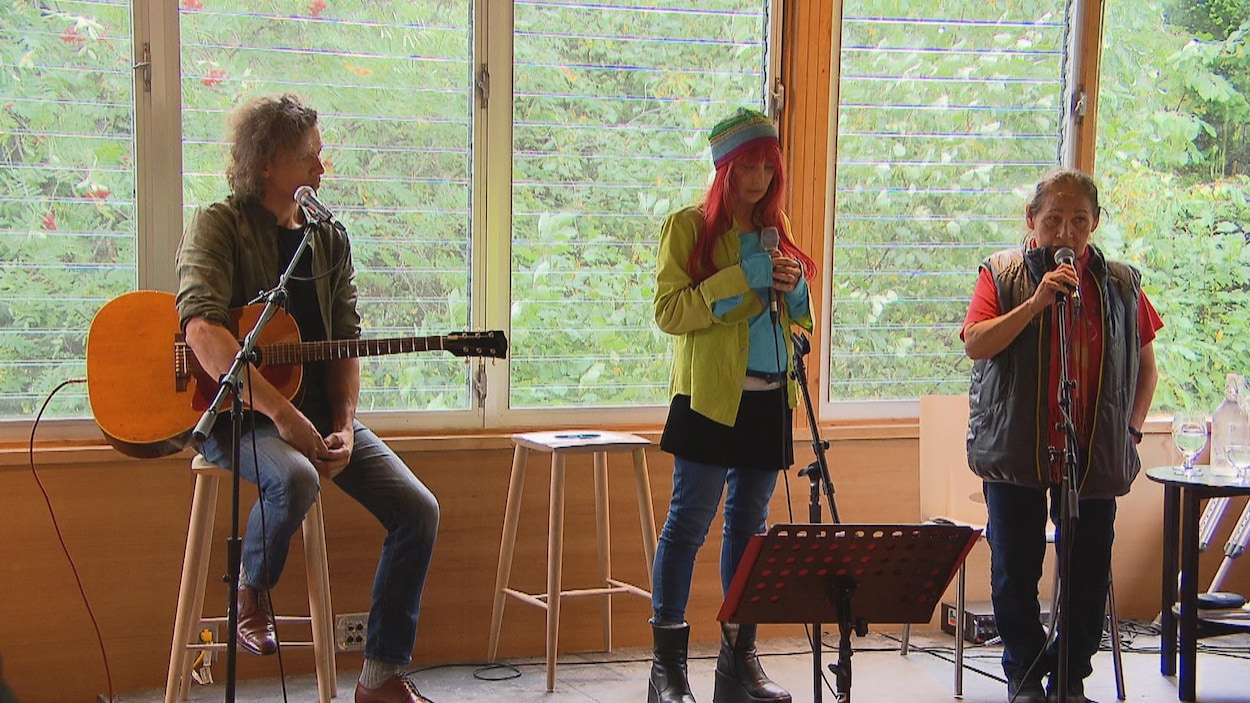 Un guitariste, Chloé Sainte-Marie et Joséphine Bacon sur scène.