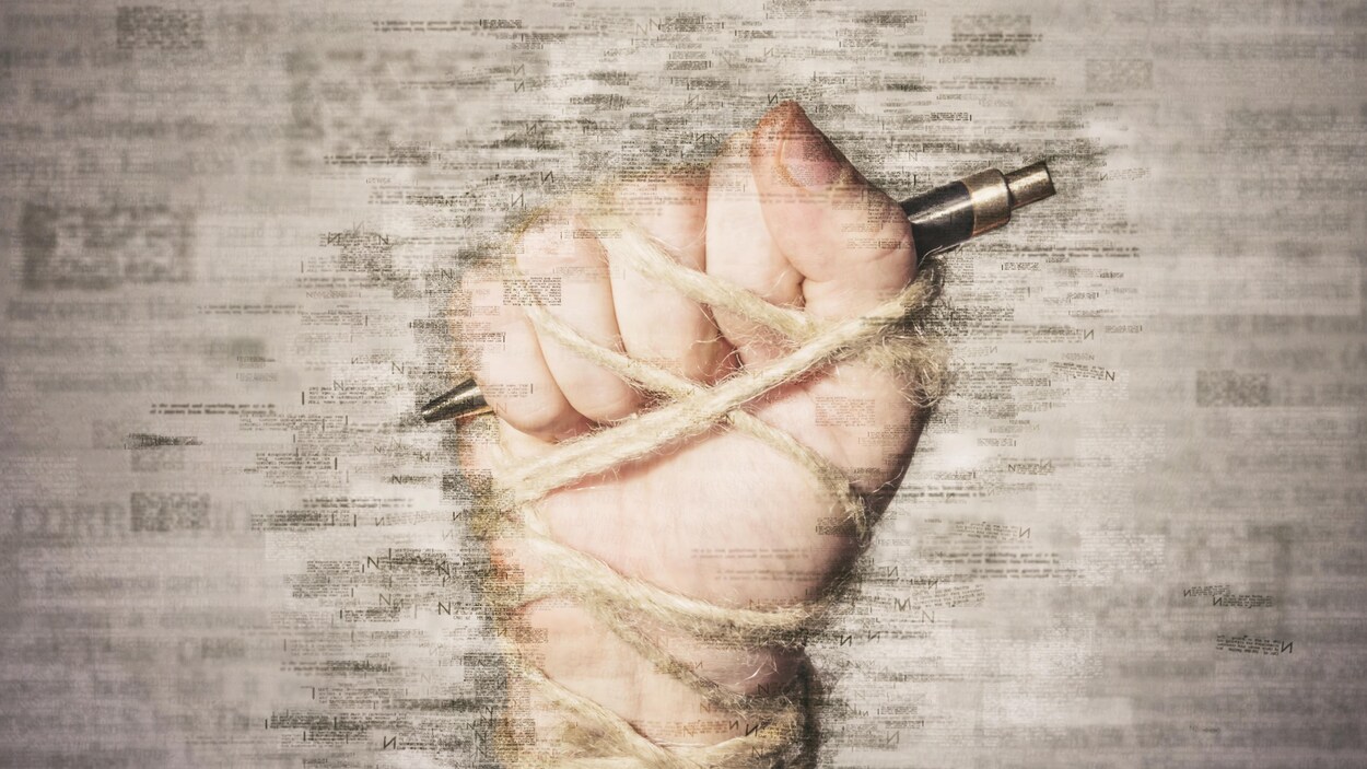 Une main tenant un stylo est attachée.