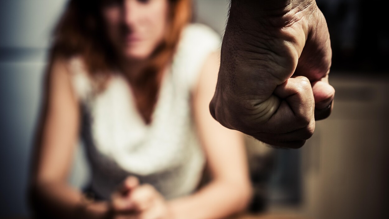 Un poing devant une femme assise. Un poing devant une femme assise.