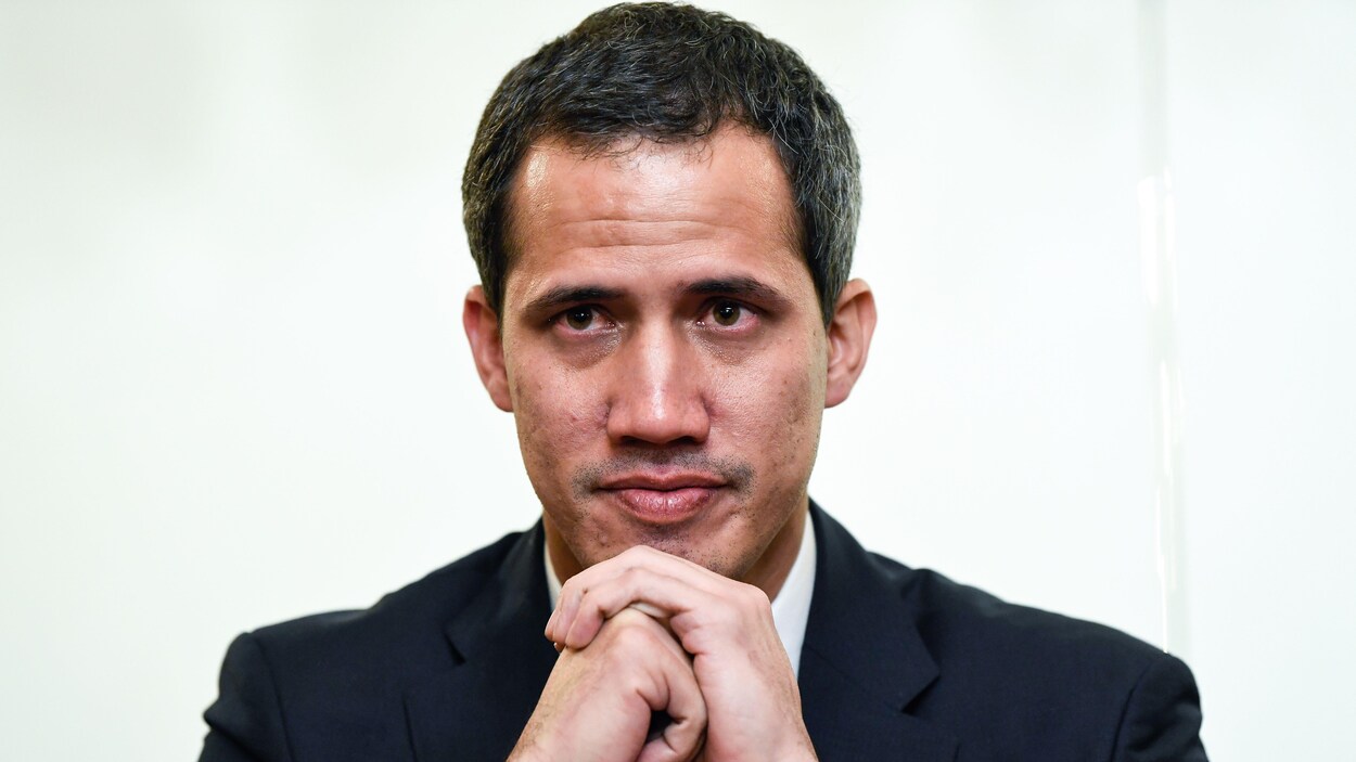 Juan Guaido, les mains croisées sous le menton, lors d'une conférence de presse.