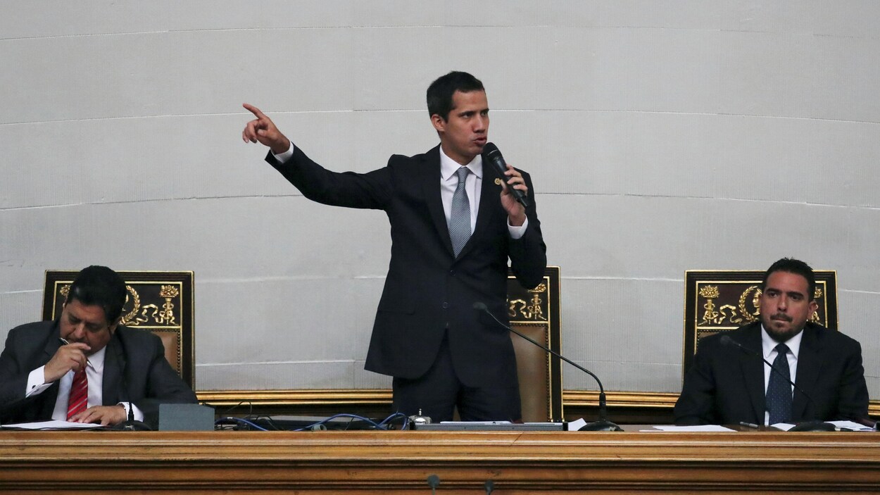 Juan Guaido est debout et parle dans un micro.