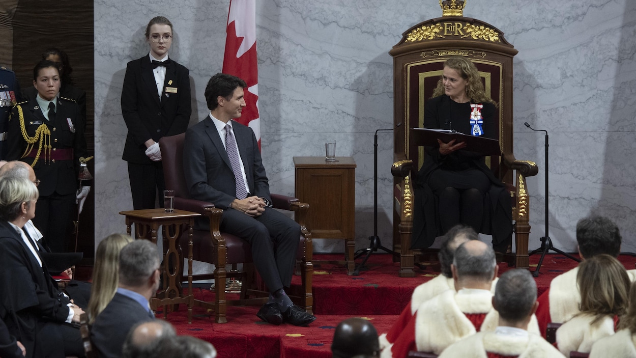 Justin Trudeau regarde Julie Payette, avec le sourire.