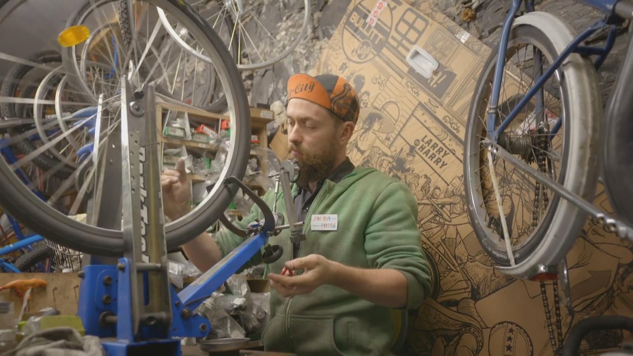 Julien Roy répare un vélo dans sa boutique.