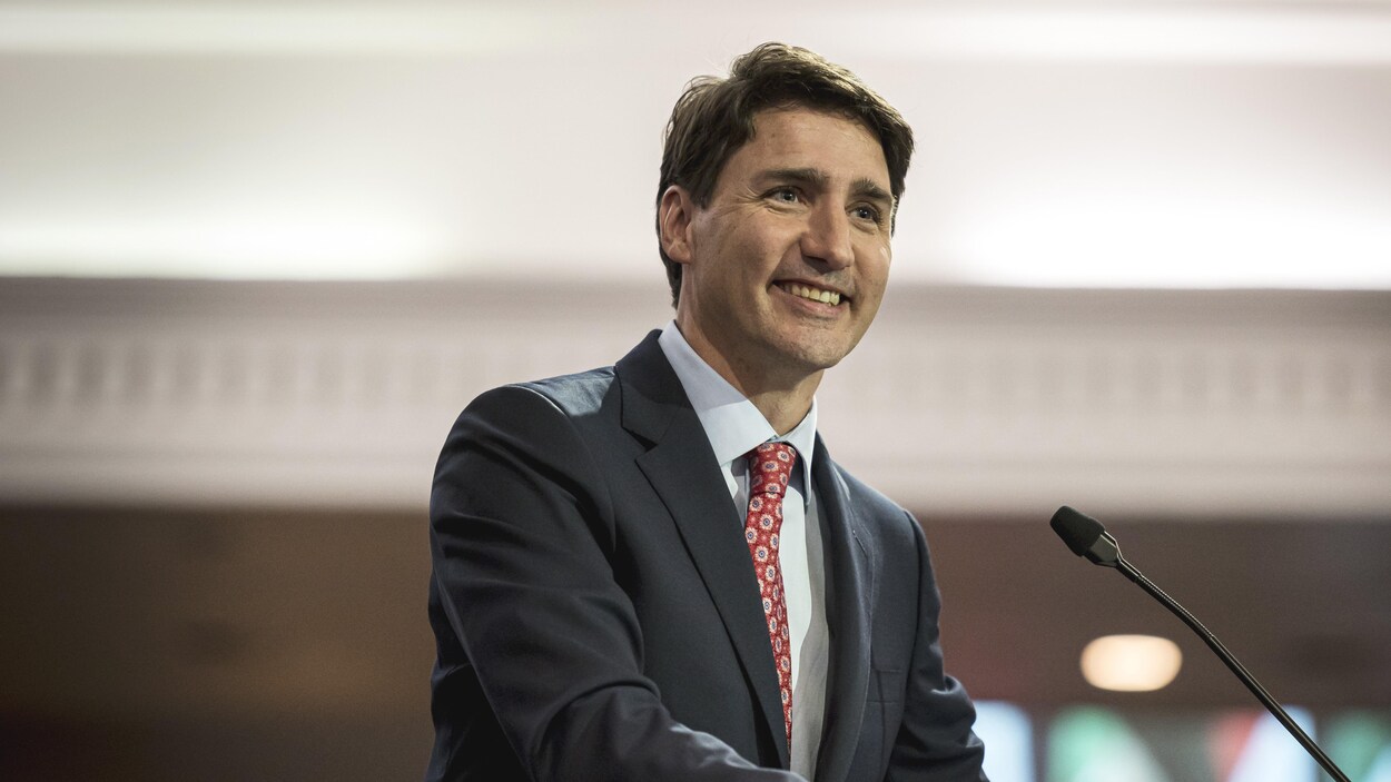 Justin Trudeau sourit lorsqu'il prononce un discours.