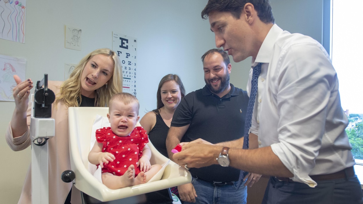 Justin Trudeau devant un bébé qui pleure sur une balance.