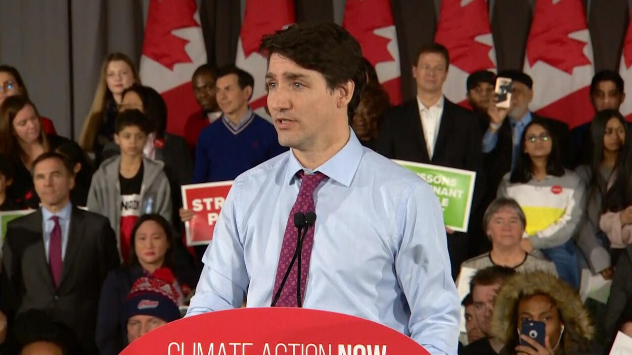 Justin Trudeau debout au podium, alors qu'on voit plusieurs partisans libéraux derrière lui.