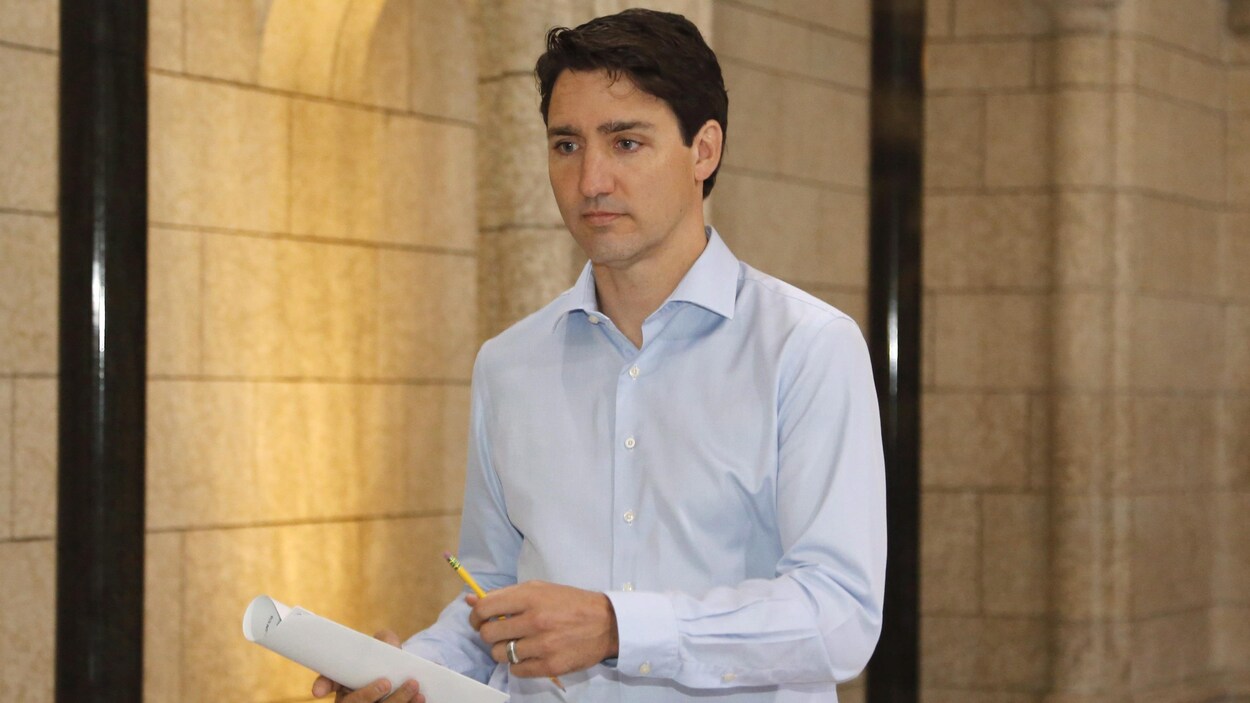 Justin Trudeau marche dans un corridor du Parlement.