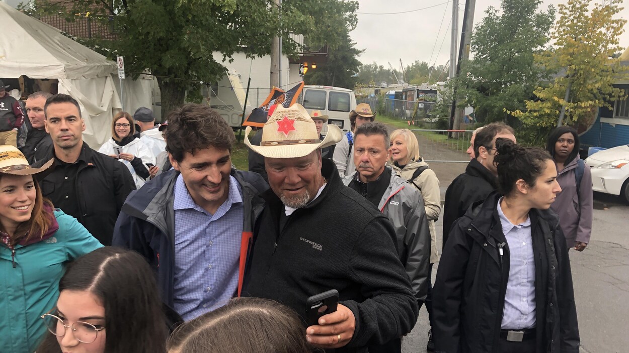 Justin Trudeau prend un égoportrait avec un homme qui porte un chapeau de cowboy.