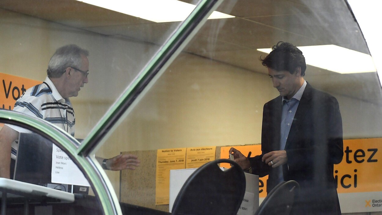 M. Trudeau met un bulletin de vote dans une boîte. M. Trudeau met un bulletin de vote dans une boîte.