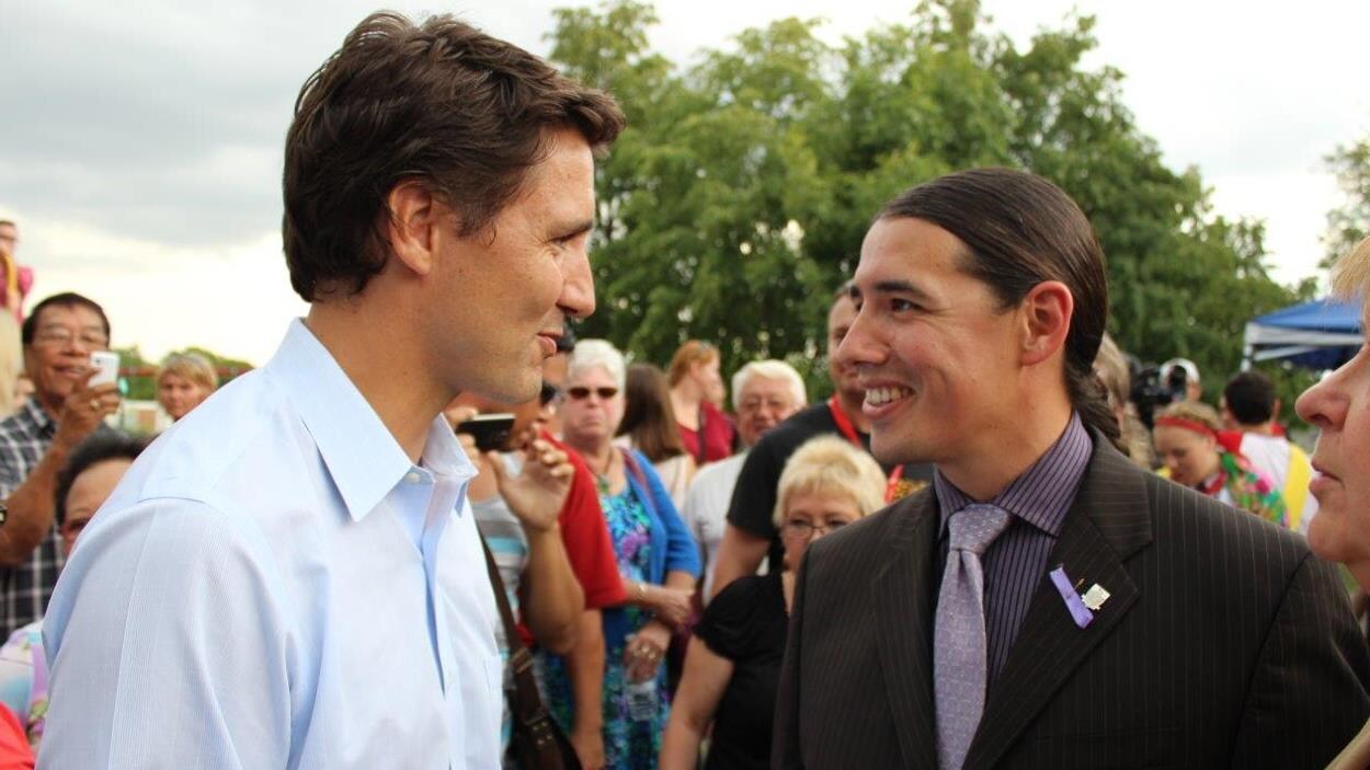 MM. Trudeau et Ouellette se font face en souriant.