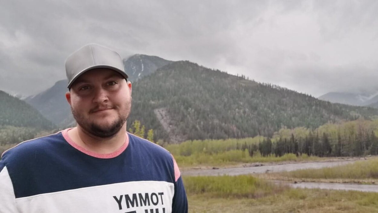 Kaden Webb devant une rivière et une montagne.