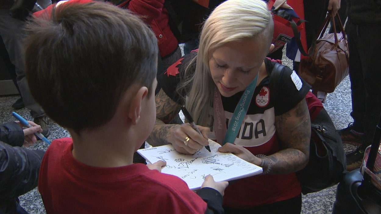 Elle signe des autographes à son retour à Calgary.