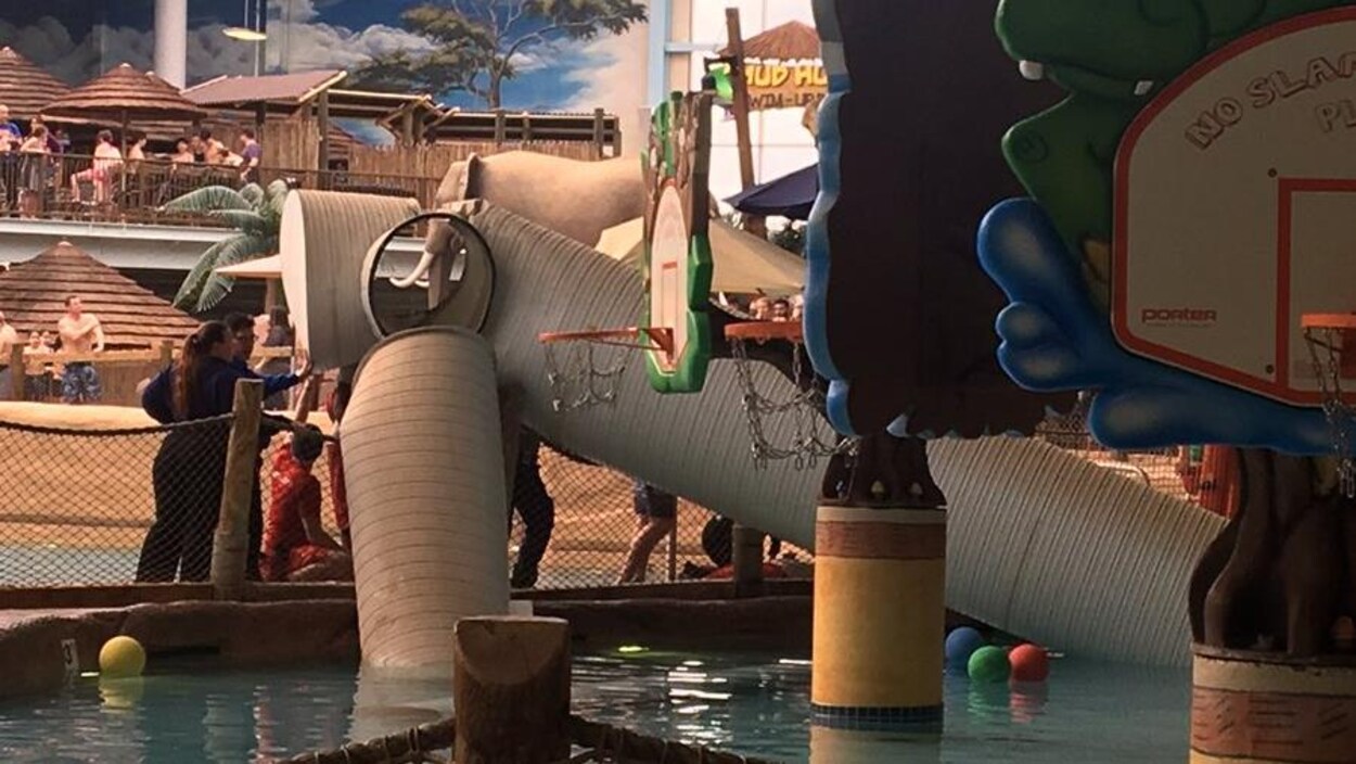 Des employés du parc aquatique observent le conduit en forme de tube tombé dans la piscine. Des employés du parc aquatique observent le conduit en forme de tube tombé dans la piscine.