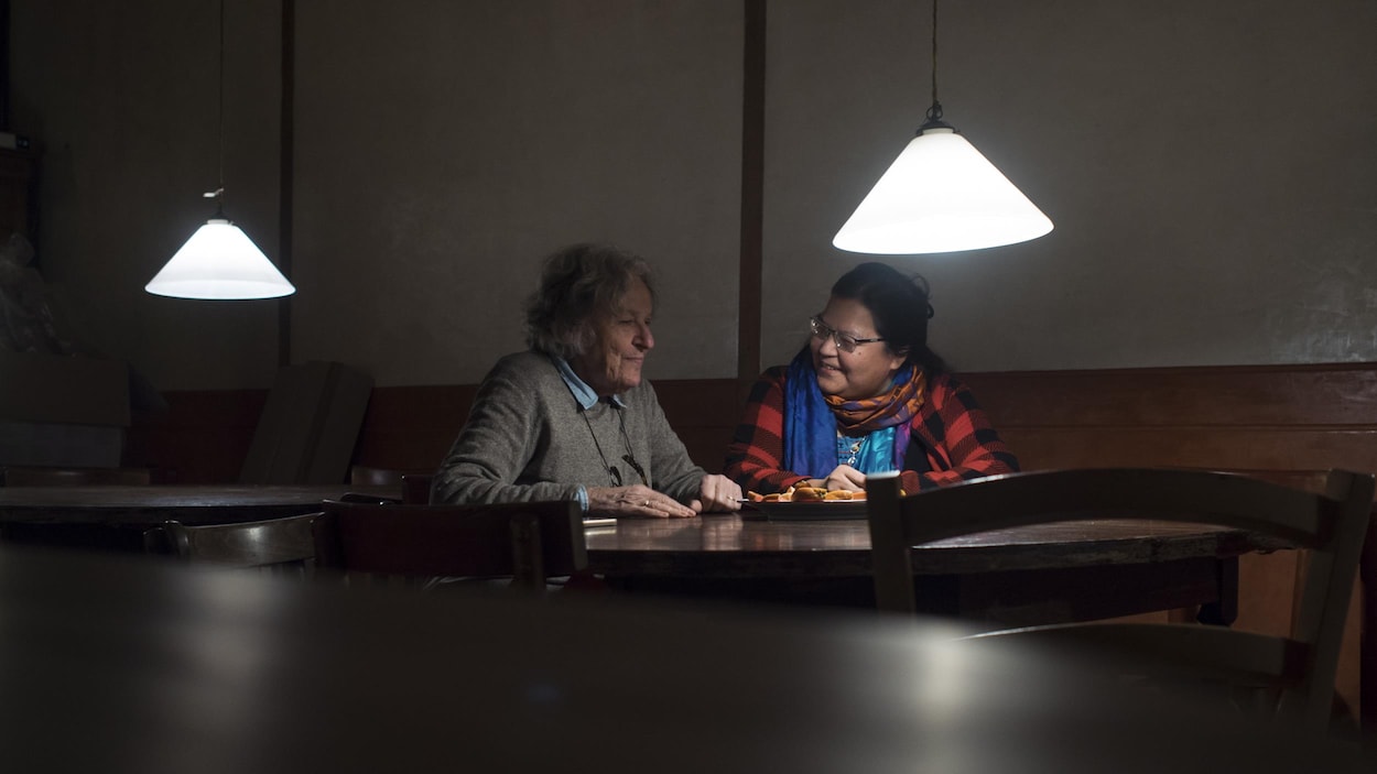 Les deux femmes sont assises dans un café et discutent entre elles.