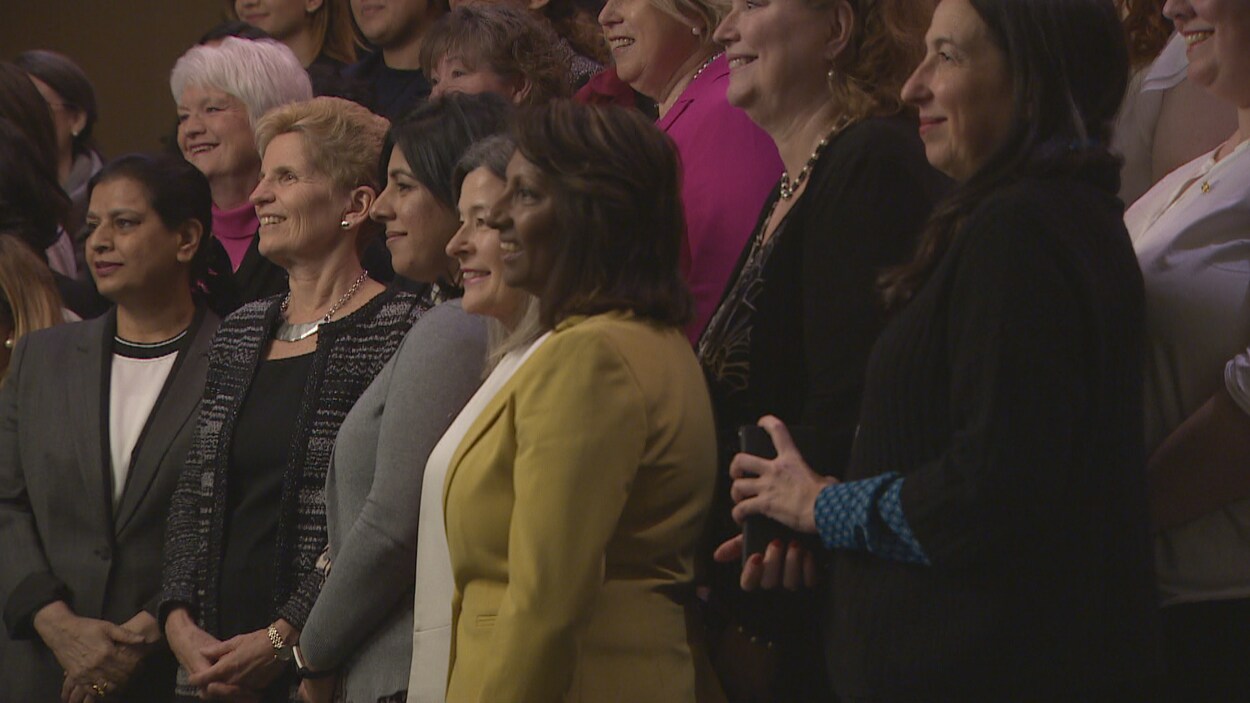 Kathleen Wynne debout qui prend une photo en compagnie de femmes députées libérales.