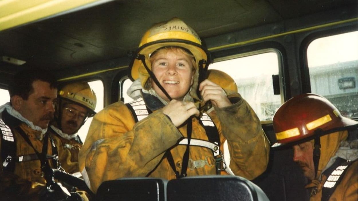 Kathy Symington en uniforme, dans un camion de pompiers.