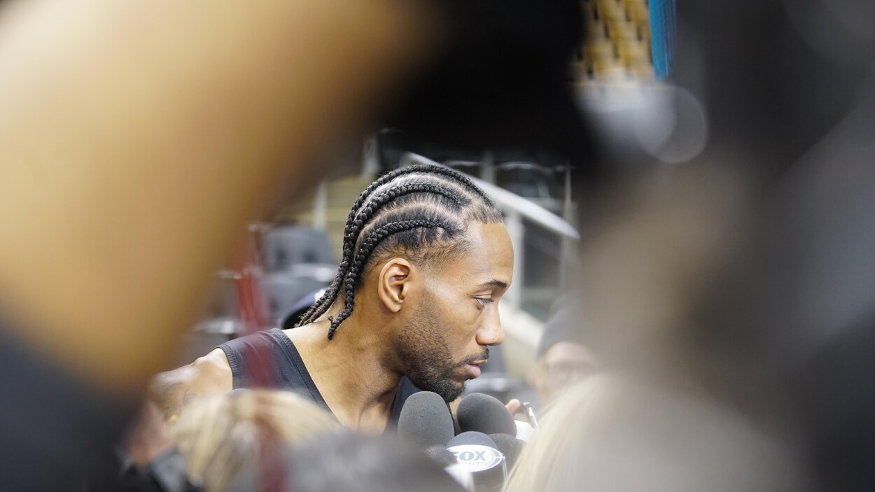 Kawhi Leonard parle à des journalistes dans une salle de sport.