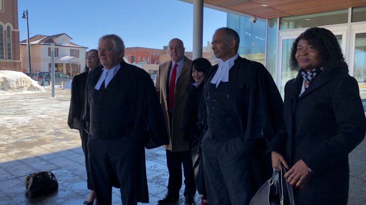 Un groupe de personnes, dont Keith Hobbs, sortant d'un bâtiment.