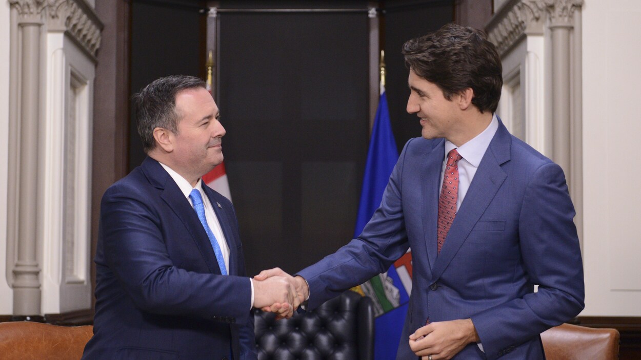 Jason Kenney et Justin Trudeau se serent la main lors d'une rencontre.