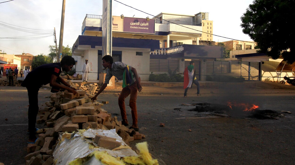 Des manifestants érigent une barricade le long d'une rue lors de manifestations dans le centre de Khartoum.