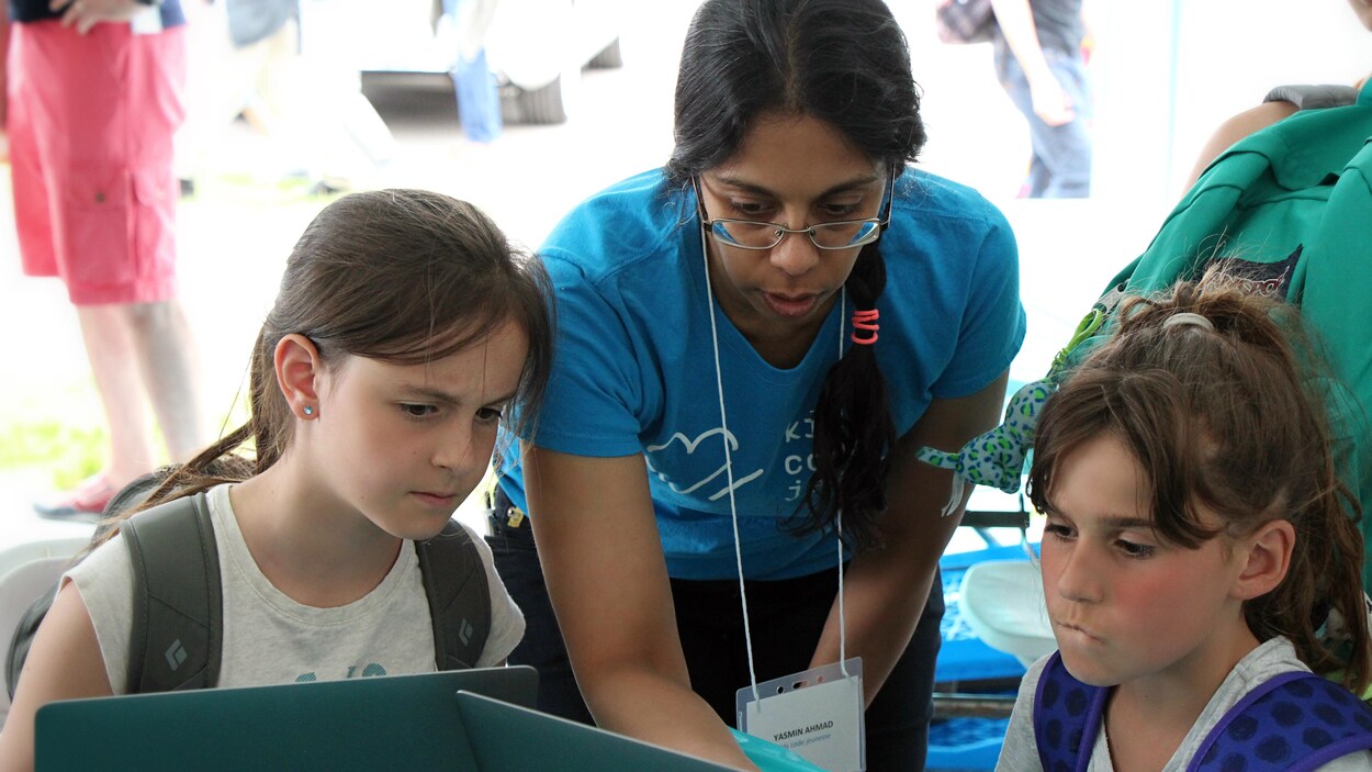 Une représentante de Kids Code Jeunesse avec des élèves. Une représentante de Kids Code Jeunesse avec des élèves.