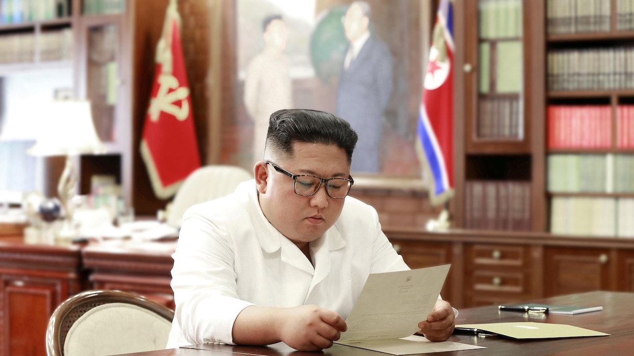 Kim Jong-un assis à son bureau en train de lire une lettre.