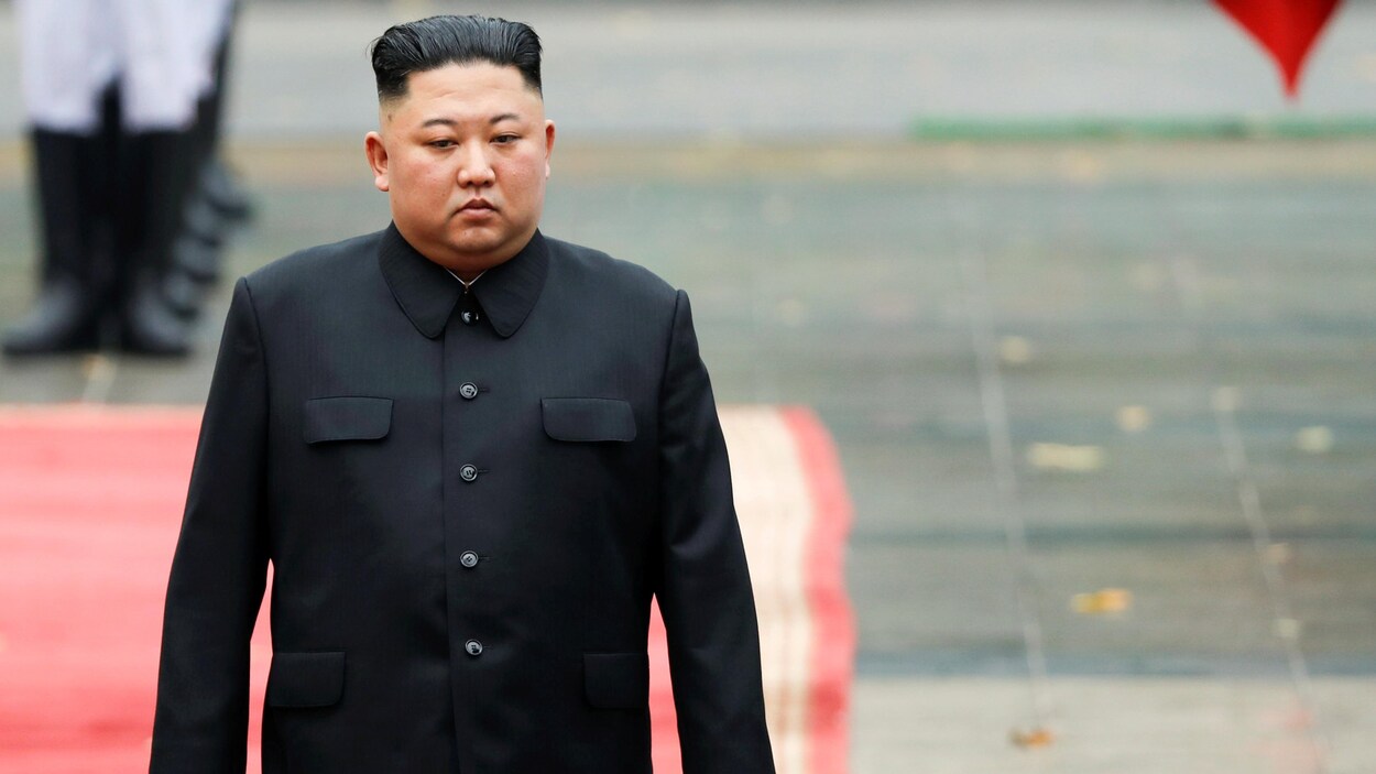 Kim Jong-un marche sur un tapis rouge.