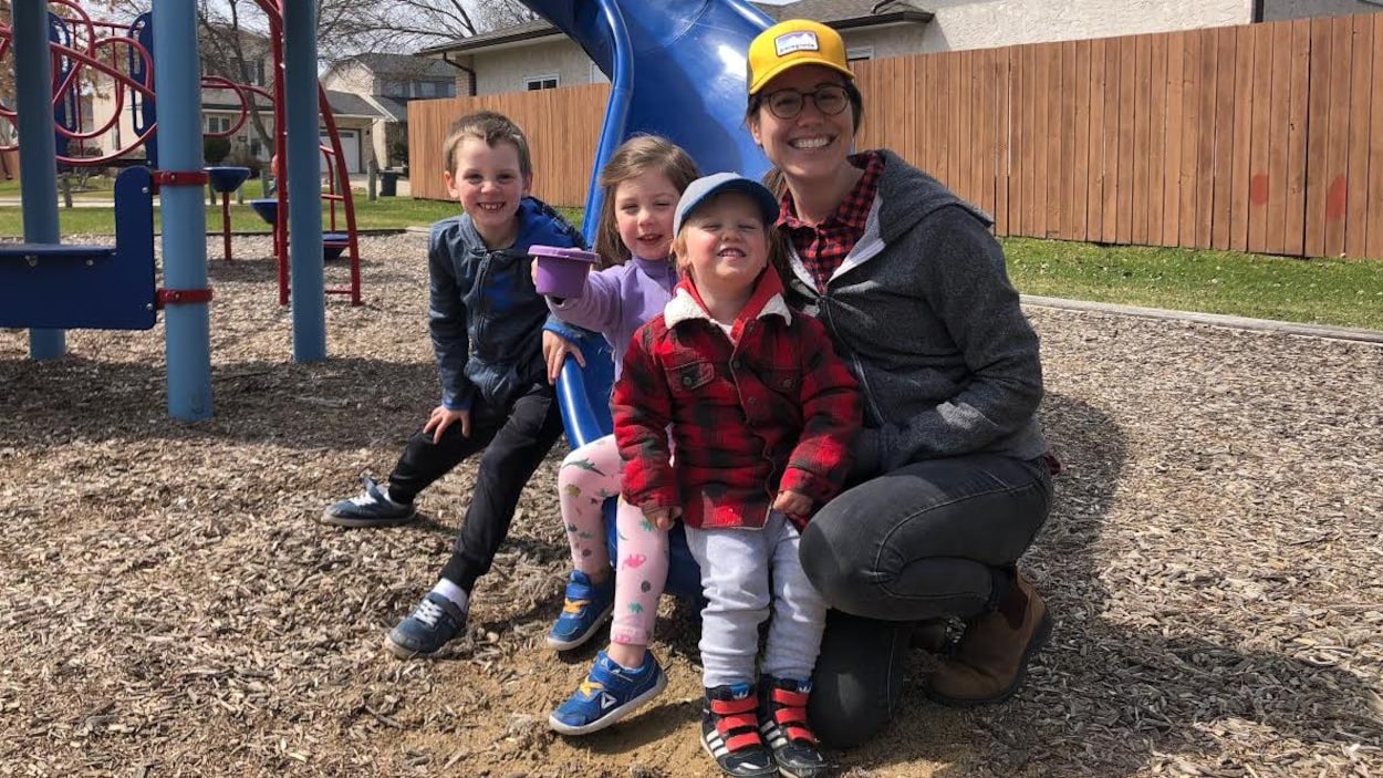 Une femme pose avec ses trois enfants de 2, 4 et 6 ans, dans un parc municipal.