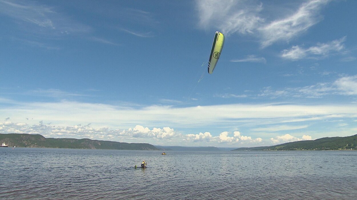 Un amateur de kitesurf se trouve devant le fjord du Saguenay.