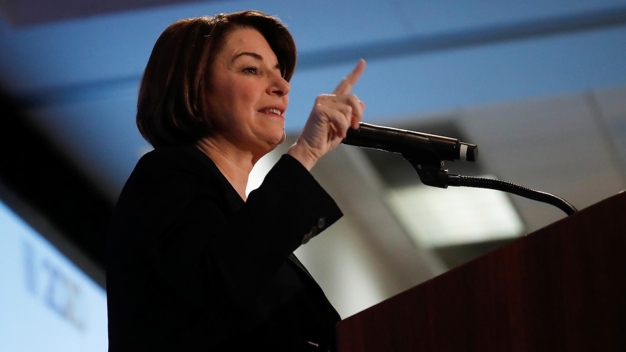 Amy Klobuchar debout, devant un lutrin.
