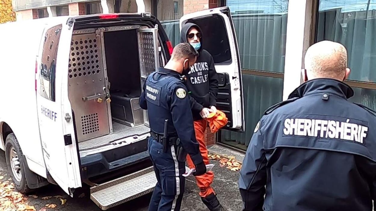 Kyle Anthony Kennedy entouré de deux policiers.