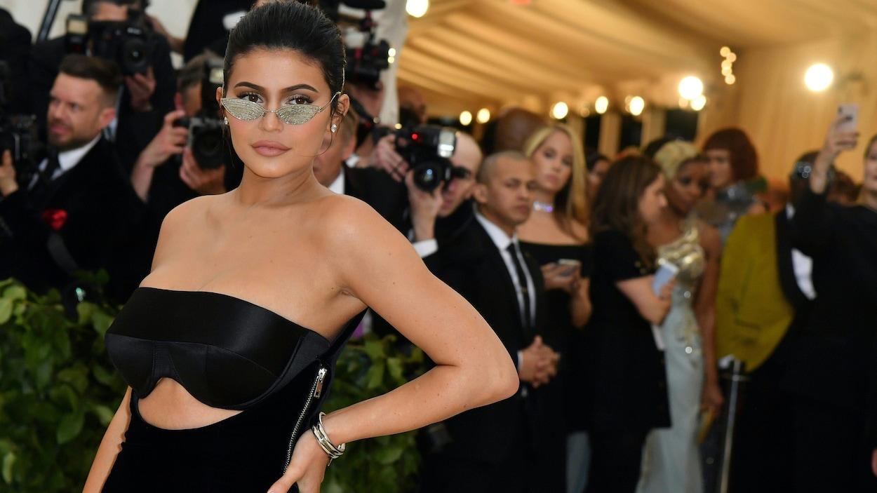 La jeune femme est vêtue d'une robe noire et de lunettes en argent. La jeune femme est vêtue d'une robe noire et de lunettes en argent.