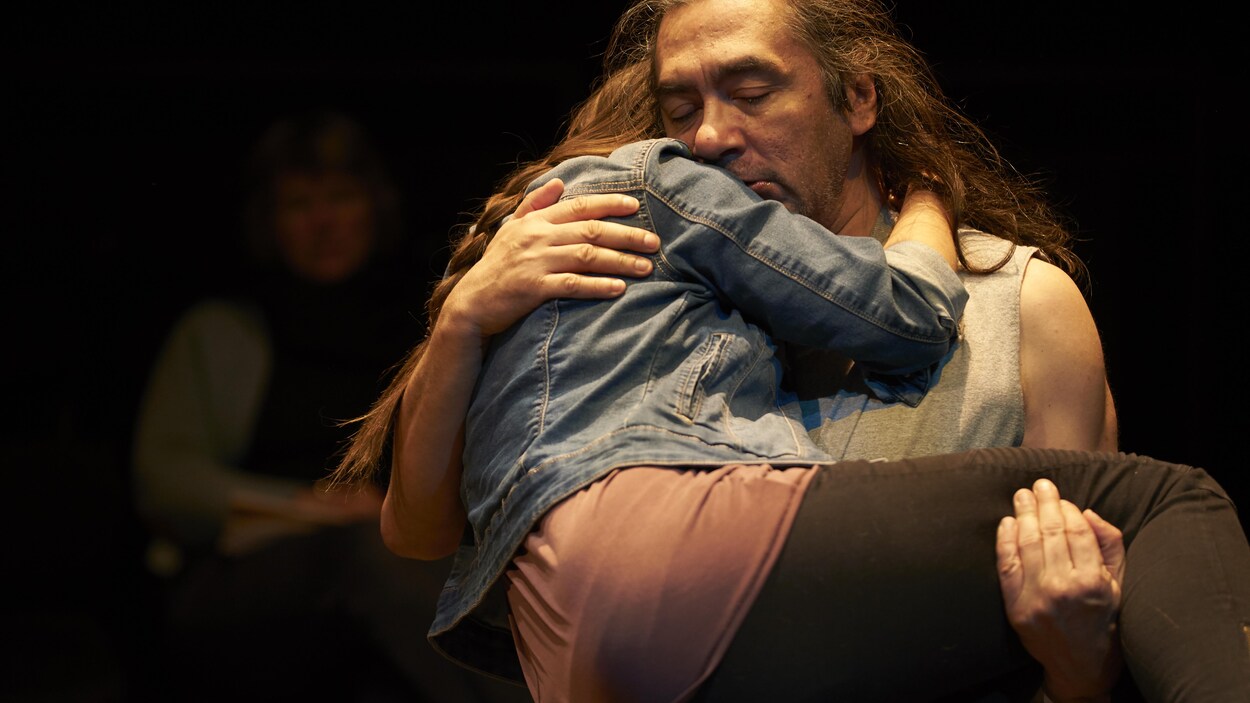 Un homme tient une jeune femme dans ses bras.