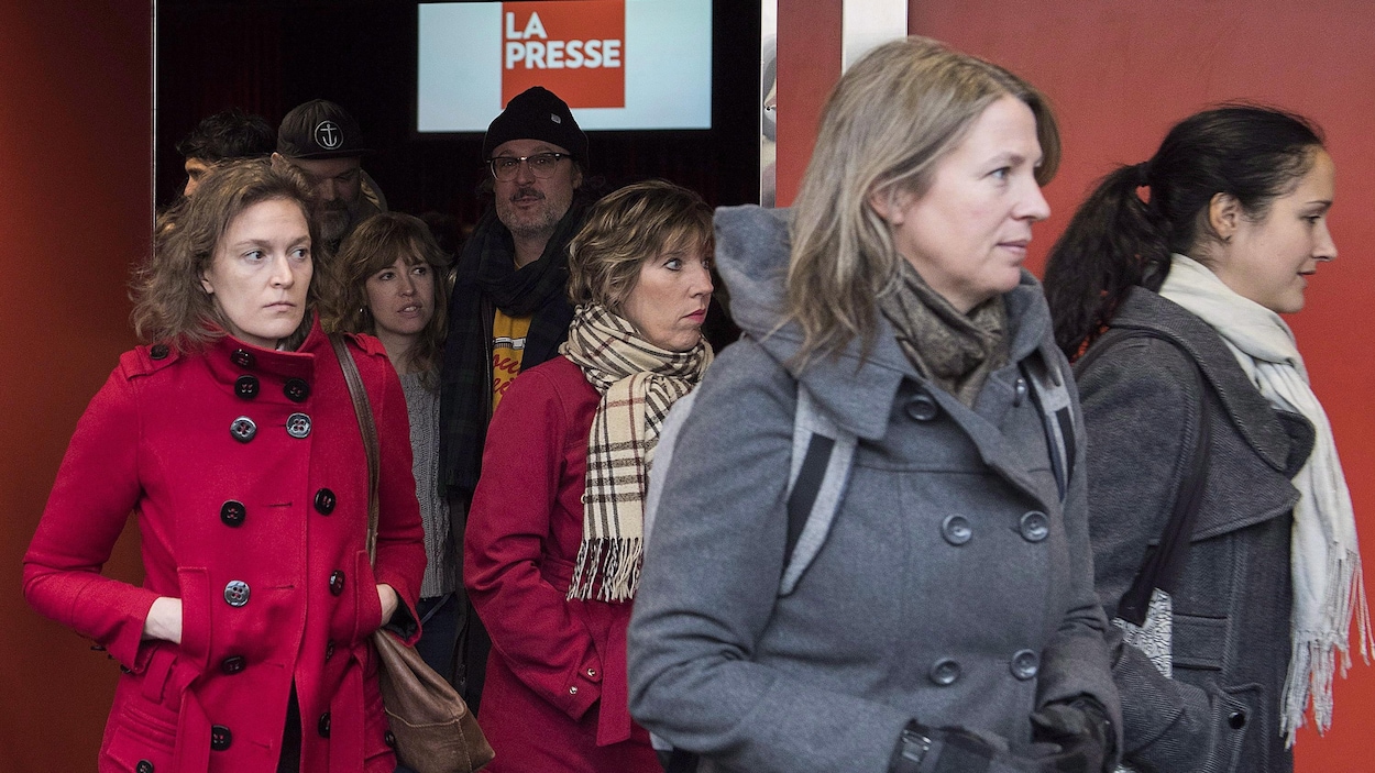 Des gens sortent d'une salle.