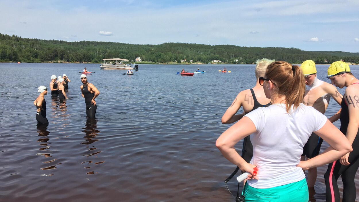 Des nageurs sont avancés dans les eaux du lac à Jim jusqu'aux genoux.