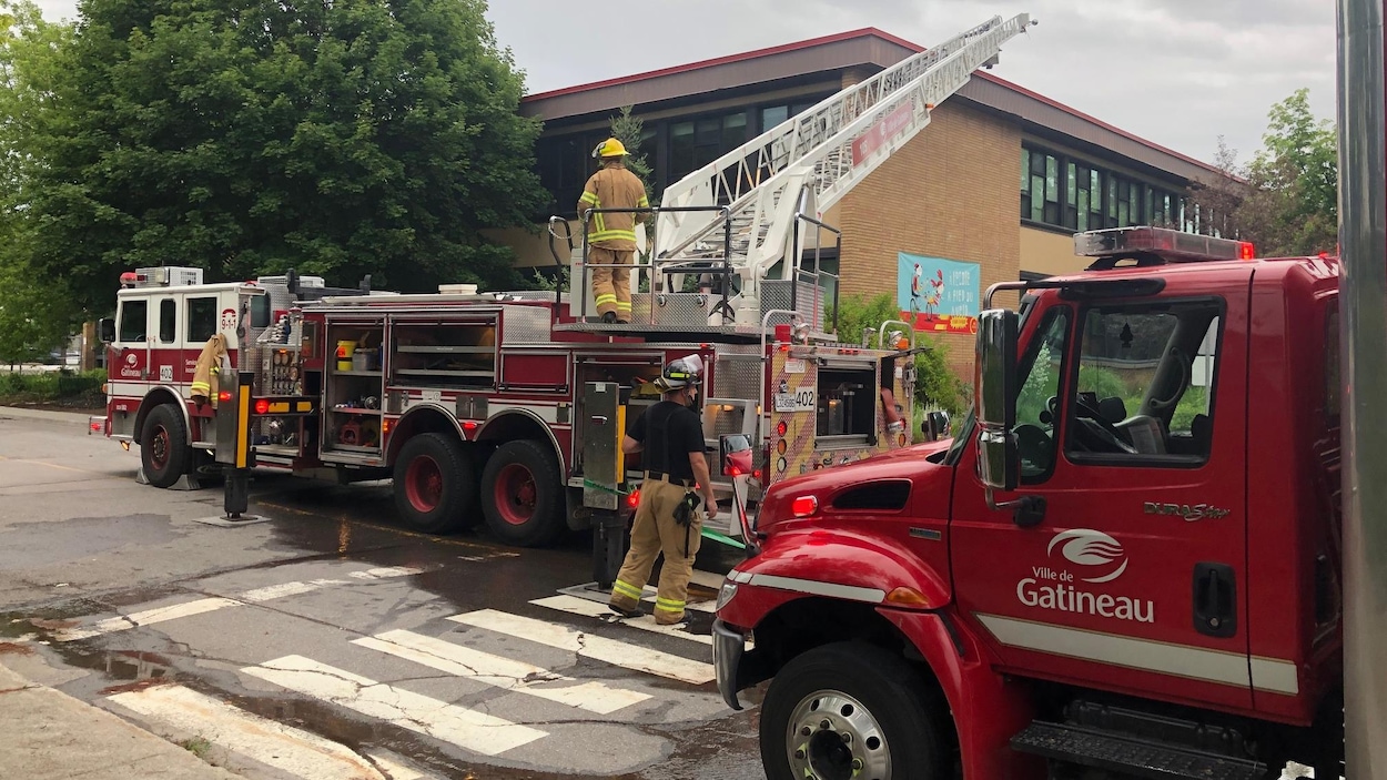 Des pompiers éteignent le feu qui a pris dans l'enceinte de l'école du Lac-des-Fées.