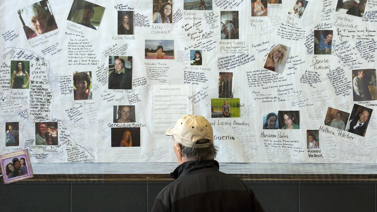 Un homme regarde des photos des victimes de la tragédie de Lac-Mégantic. Un homme regarde des photos des victimes de la tragédie de Lac-Mégantic.