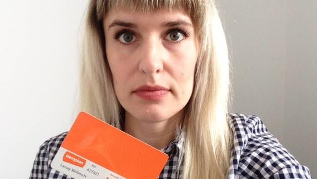 Photo d'une femme aux cheveux blonds qui tient une carte Aeroplan orange dans une main. Photo d'une femme aux cheveux blonds qui tient une carte Aeroplan orange dans une main.