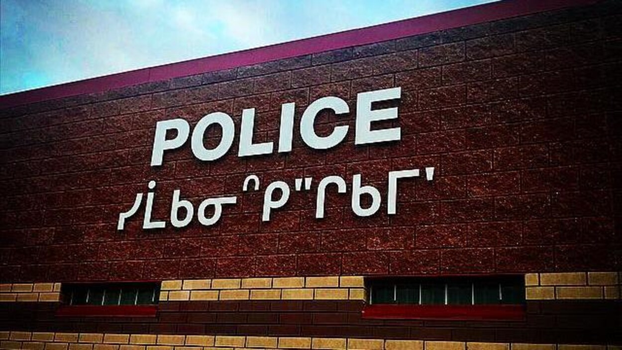 Panneau avec le nom du service de police écrit en anglais et en cri.