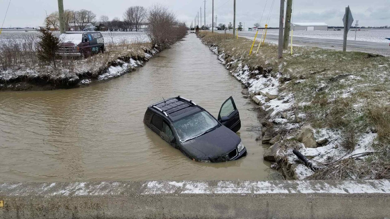 Une voiture a glissé sur la chaussée et s'est retrouvée dans un fossé rempli d'eau. Une voiture a glissé sur la chaussée et s'est retrouvée dans un fossé rempli d'eau.