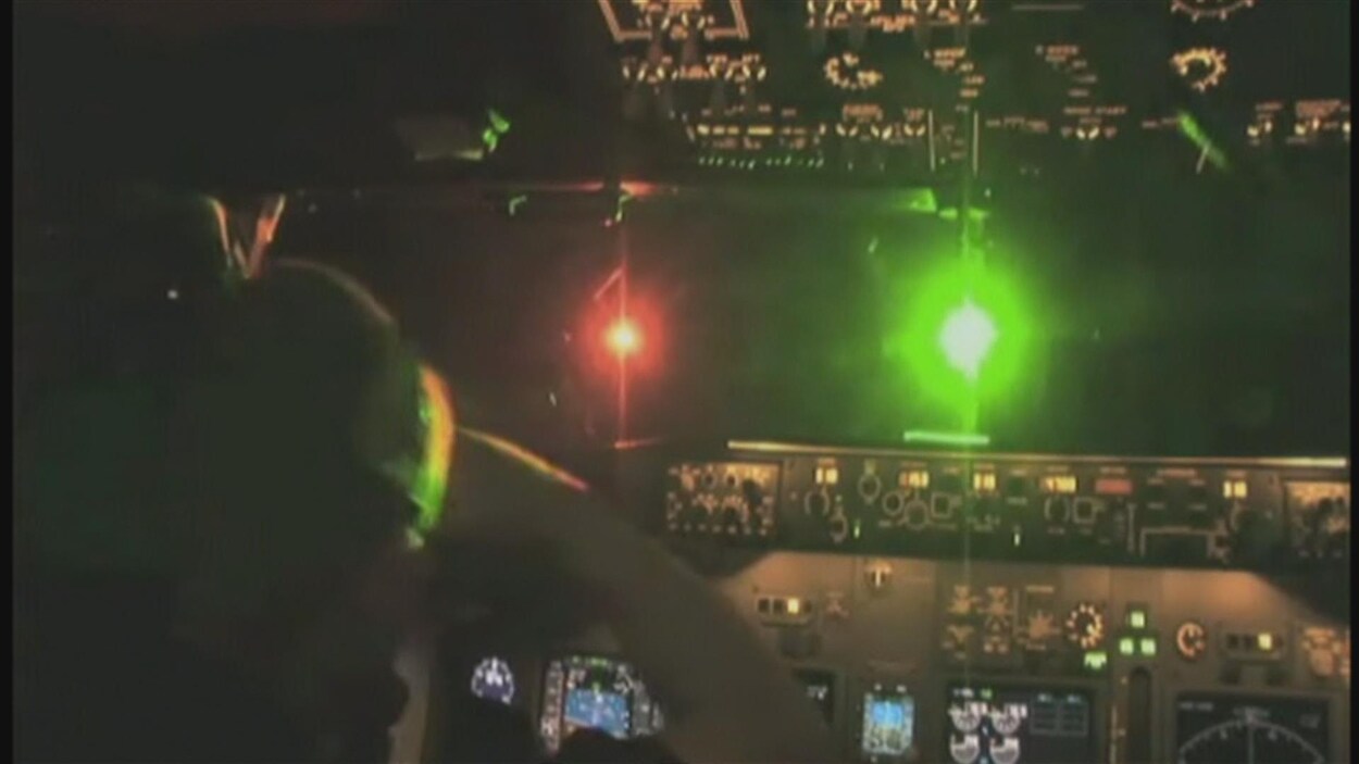 Une lumière verte aveuglante pour un pilote aux commandes d'un avion.