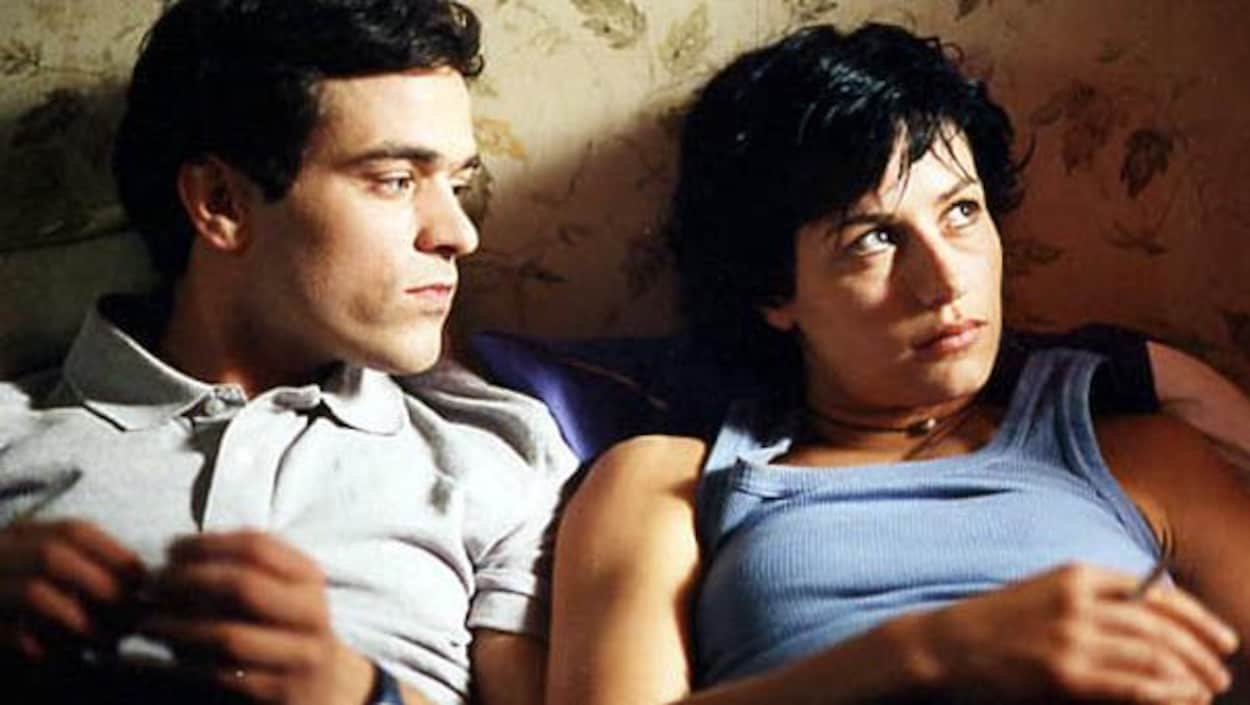 Un homme et une femme sont allongés côte à côte dans un lit.