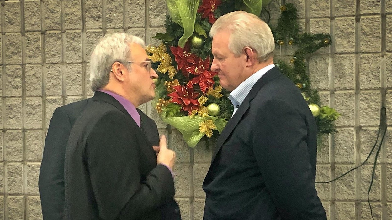 Pierre Dufour et David Lauzon discutent dans un corridor.